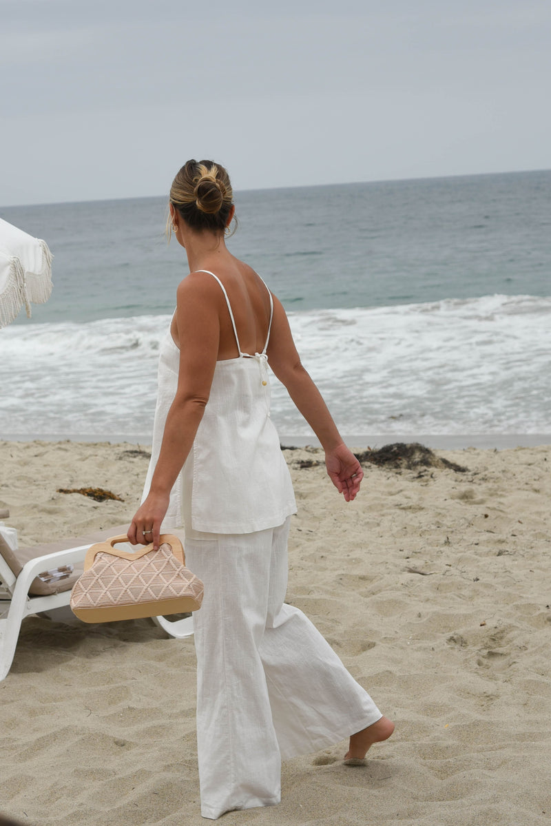 Woman in a white linen pant and tank matching set outfit 
